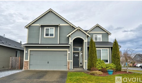 A two-story house with a garage and a front yard.