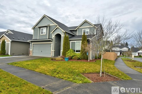 A house with a grey roof and a driveway in front.