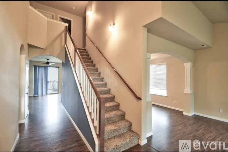 A staircase with a carpeted runner leads up to a landing with a window.