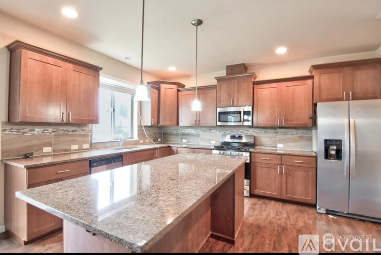 A kitchen with wooden cabinets and granite countertops.