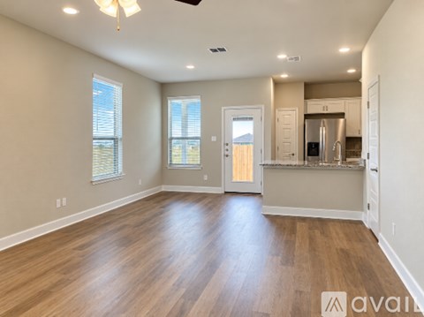A spacious room with wooden floors and a ceiling fan.