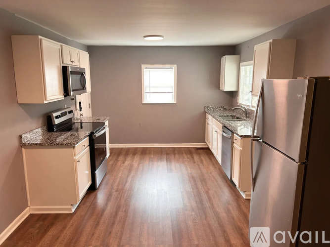 A kitchen with wooden floors and stainless steel appliances.