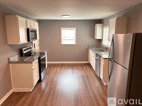 A kitchen with wooden floors and stainless steel appliances.