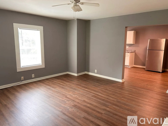 A room with wooden floors and a ceiling fan.