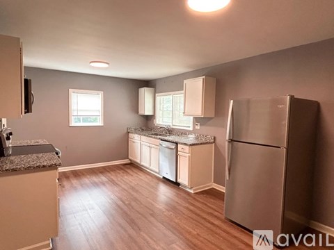 A kitchen with a refrigerator, cabinets, and a countertop.