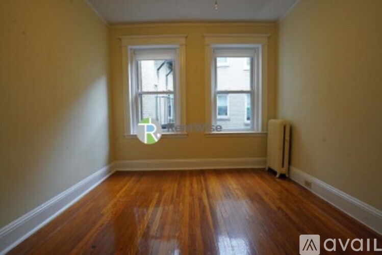 A room with wooden floors and two windows.