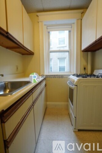 A kitchen with white cabinets and a window.