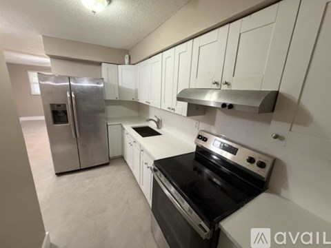 A kitchen with white cabinets and stainless steel appliances.