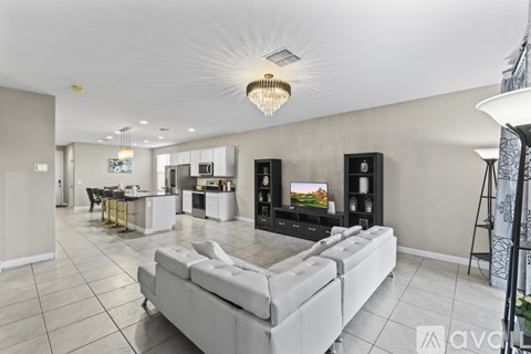 A modern living room with a white sofa and a chandelier.