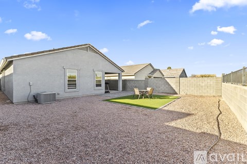 A house with a grey exterior and a gravel driveway.