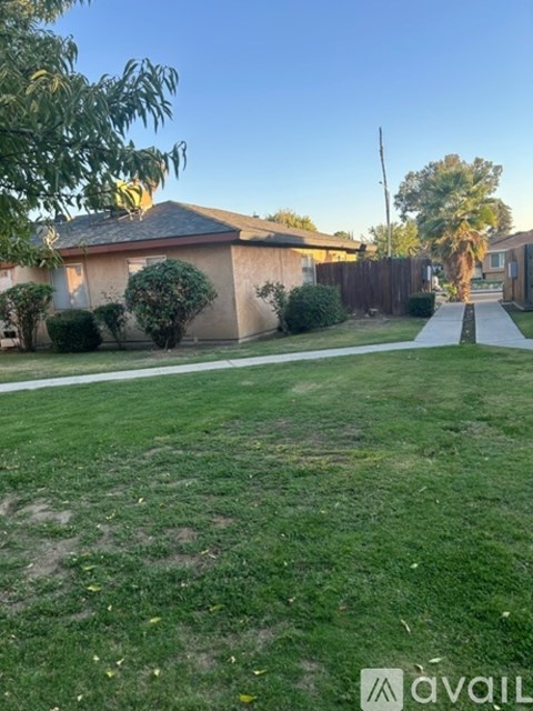 A backyard with a lawn and a house in the background.