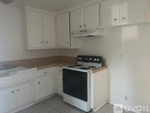 A kitchen with white cabinets and a black stove top oven.