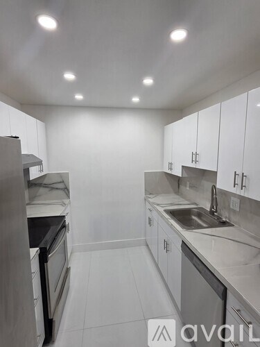A kitchen with white cabinets and a sink.
