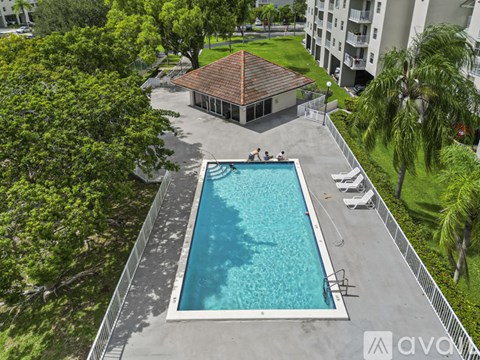 A small pool surrounded by a fence and trees.