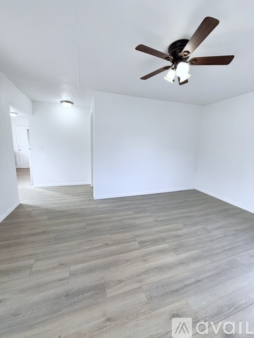 A room with a ceiling fan and light fixture.