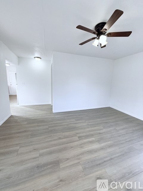 A room with a ceiling fan and light fixture.