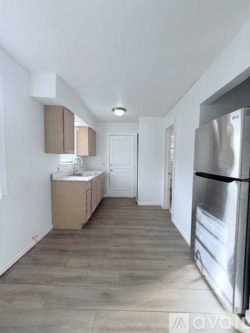 A kitchen with a refrigerator on the right side.