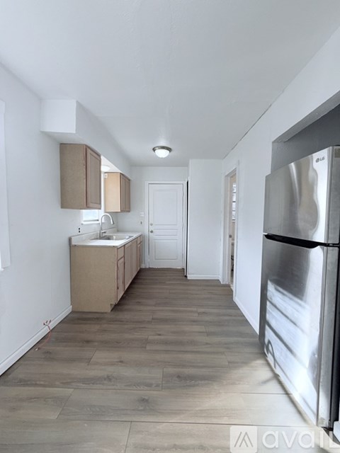 A kitchen with a refrigerator on the right side.