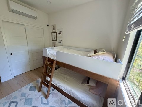 A small bedroom with a bunk bed and a window.