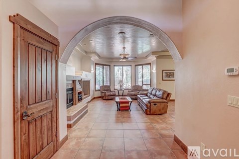 A spacious living room with a large couch and a fireplace.