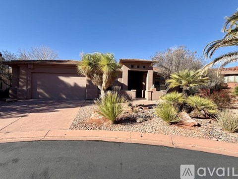 A house with a driveway and palm trees in front.