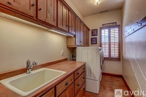A kitchen with wooden cabinets and a white sink.