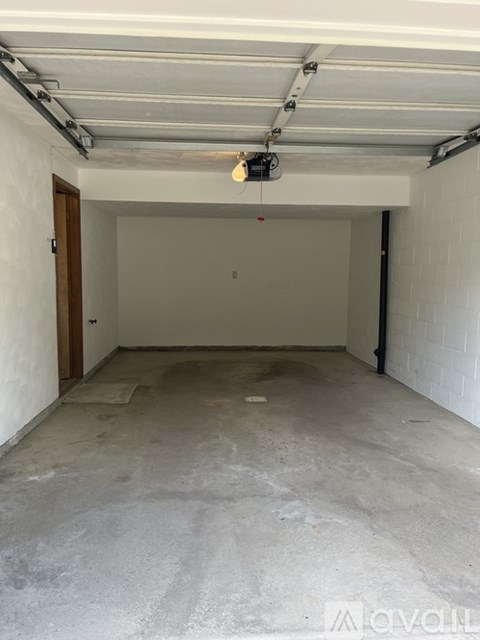 A spacious garage with a concrete floor and white walls.