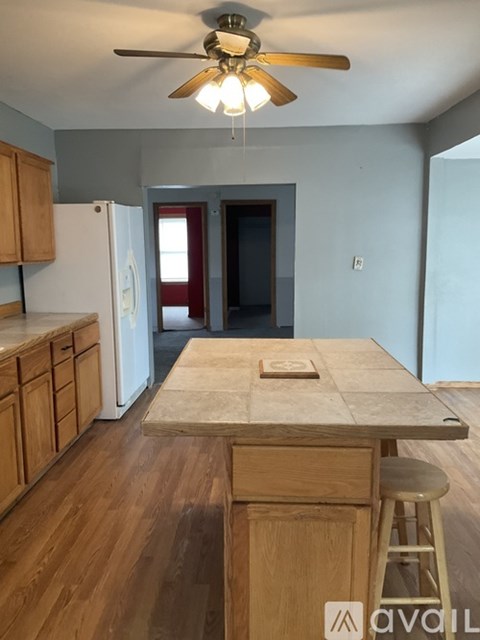 A kitchen with wooden cabinets and a white fridge.
