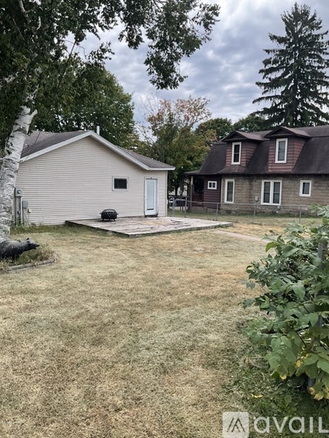 A backyard with a shed and a house.