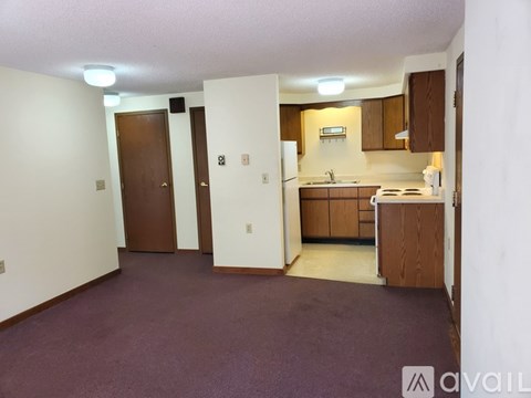 A kitchen area with a sink, stove, and cabinets.