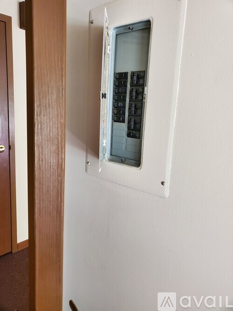 A white wall with a small window and a wooden door.