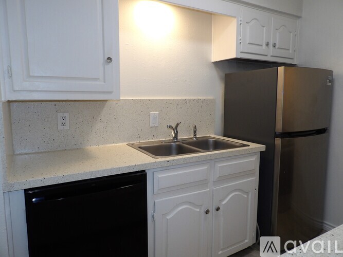 A kitchen with white cabinets and a black dishwasher.