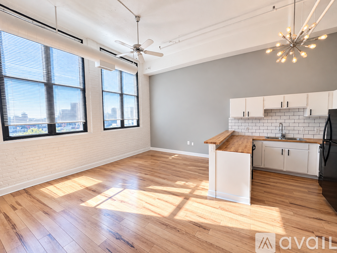 A kitchen with a wooden floor and a ceiling fan.