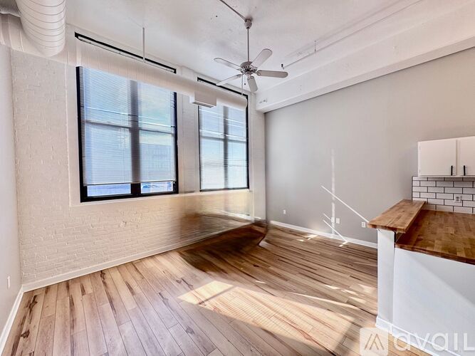 A room with wooden floors and a ceiling fan.