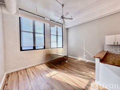 A room with wooden floors and a ceiling fan.