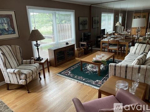 A living room with a striped chair and a striped couch.