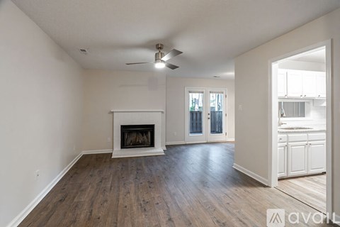A living room with a fireplace and wood flooring.