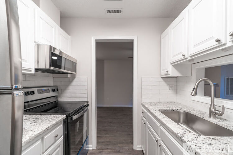 A kitchen with white cabinets and a stainless steel oven.