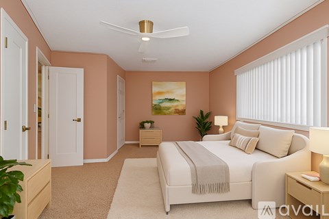 A bedroom with a bed, nightstands, and a ceiling fan.