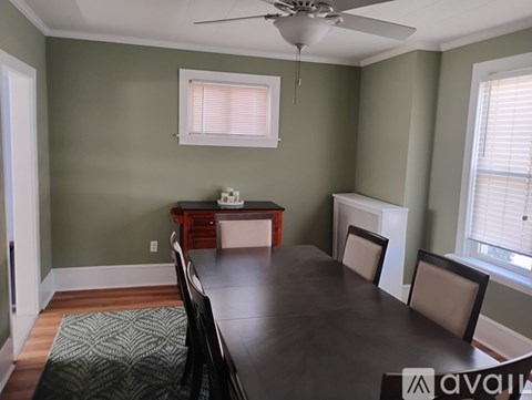 A dining room with a table, chairs, and a ceiling fan.
