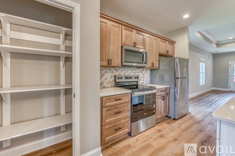 A kitchen with wooden cabinets and a stainless steel refrigerator.