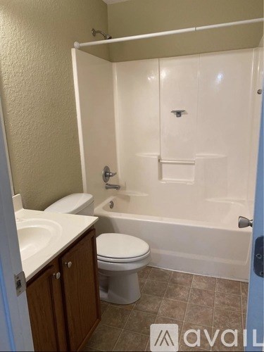 A bathroom with a toilet, sink, and bathtub.