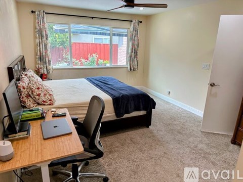A bedroom with a bed, desk, and chair.
