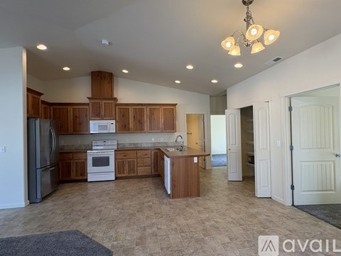 A kitchen with wooden cabinets and a refrigerator.