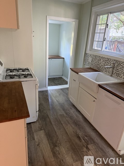A kitchen with a white stove and wooden countertops.
