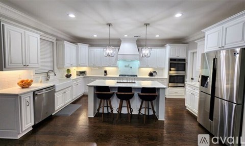 A modern kitchen with white cabinets and stainless steel appliances.