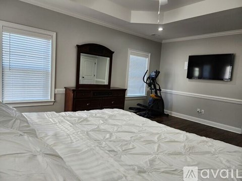 A bedroom with a large bed and a vacuum cleaner.
