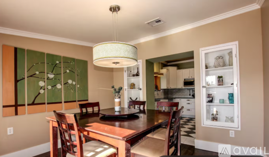 A dining room with a table and chairs and a chandelier.