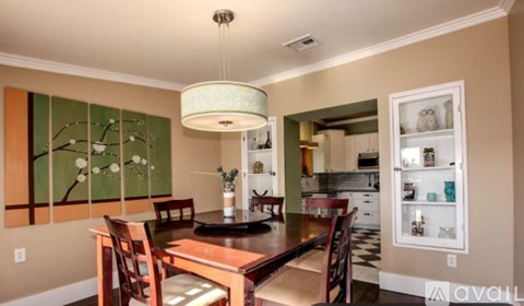 A dining room with a table and chairs and a chandelier.