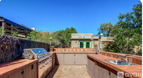 A backyard with a wooden deck and a hot tub.
